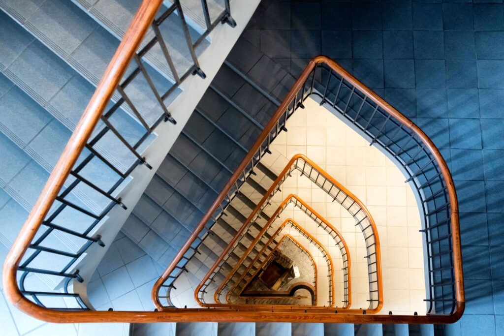 Top-down view of a modern spiral staircase with wooden handrails in Hamburg.